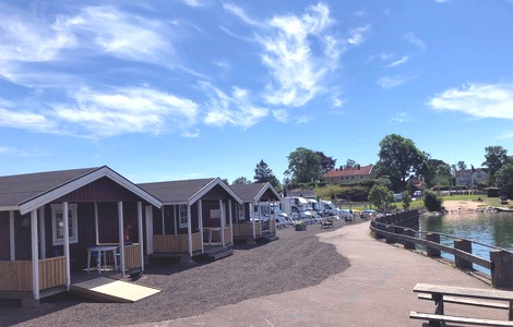 Tre röda campingstugor i Hästholmens hamn