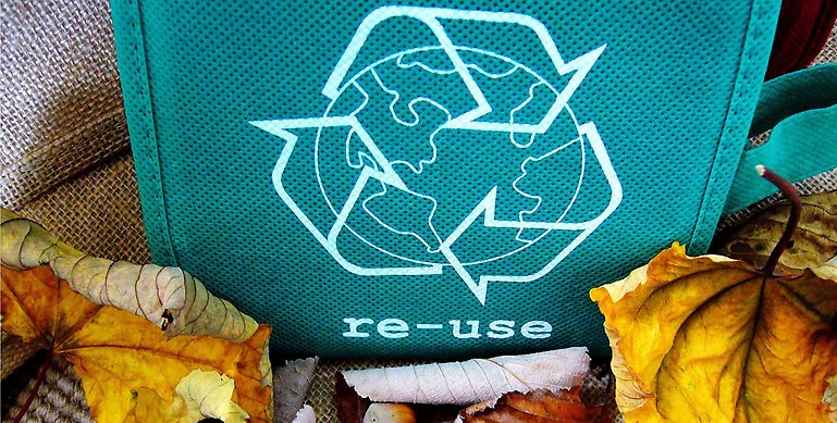 Bild på återvinningspåse och löv